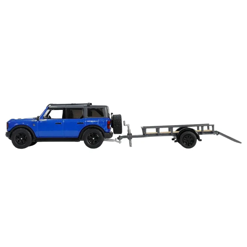 Side profile of GreenLight 2021 Ford Bronco Black Diamond connected to a utility trailer.
