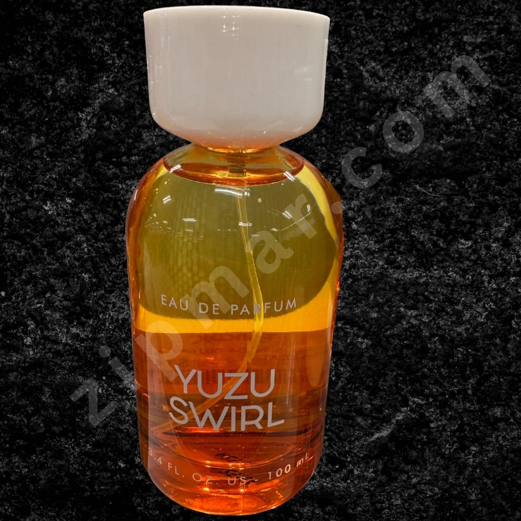 Bottle of Yuzu Swirl eau de parfum on a dark background
