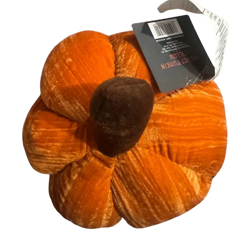 Top view showing brown stem and crushed velvet ridges of pumpkin pillow