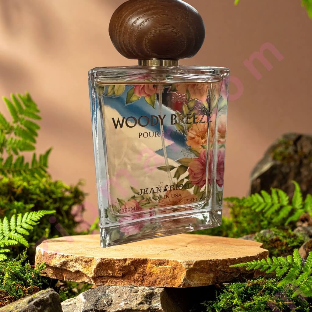 Perfume bottle labeled 'Woody Breeze' on a wooden platform with a natural background