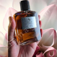 Thumbnail for Hand holding a bottle of ANE UP perfume with pink flowers in the background
