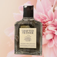 Thumbnail for Perfume bottle labeled 'Crafted Vetiver' with pink flowers in the background