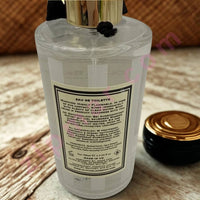 Thumbnail for Clear perfume bottle with gold cap on a wooden surface