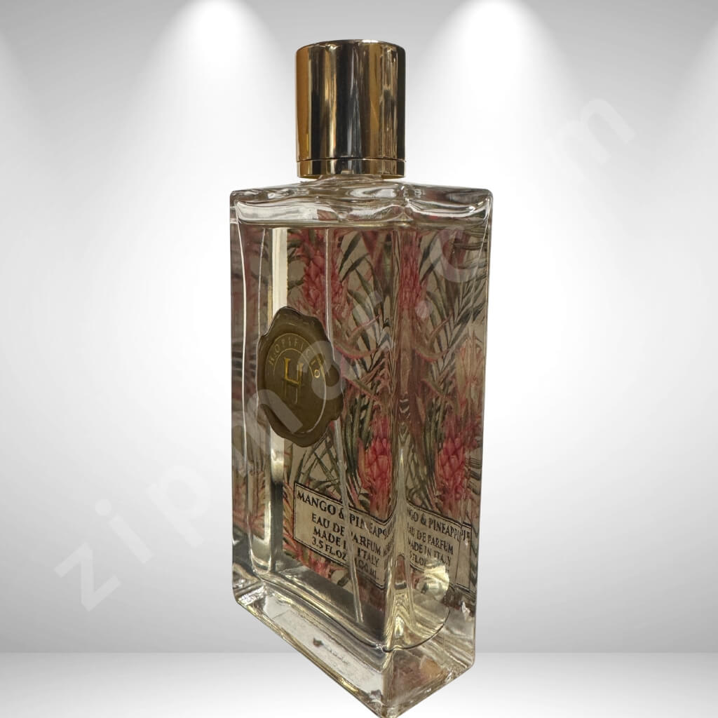 Clear perfume bottle with decorative label on a white background