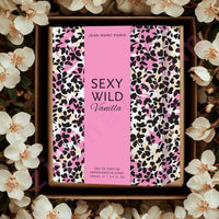 Thumbnail for Perfume bottle with 'Sexy Wild Vanilla' packaging surrounded by flowers