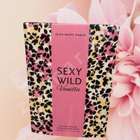 Thumbnail for Perfume bottle with 'Sexy Wild Vanilla' packaging and 'Jean Marc Paris' branding, surrounded by pink flowers.