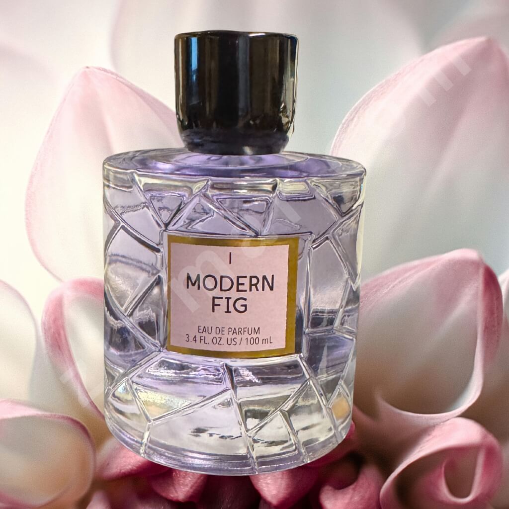 Perfume bottle labeled 'Modern Fig' surrounded by pink flowers