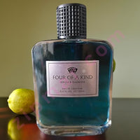 Thumbnail for Perfume bottle labeled 'Four of a Kind' with a lemon on a reflective surface.