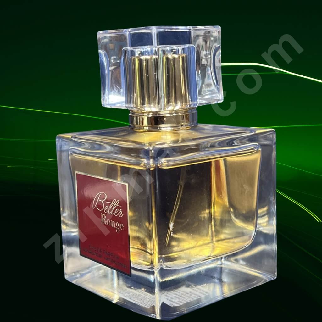 Clear perfume bottle with gold cap on a green background
