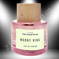 Thumbnail for Pink perfume bottle with wooden cap labeled 'Moody Ring' by 'The Good Scent' on a gradient background.