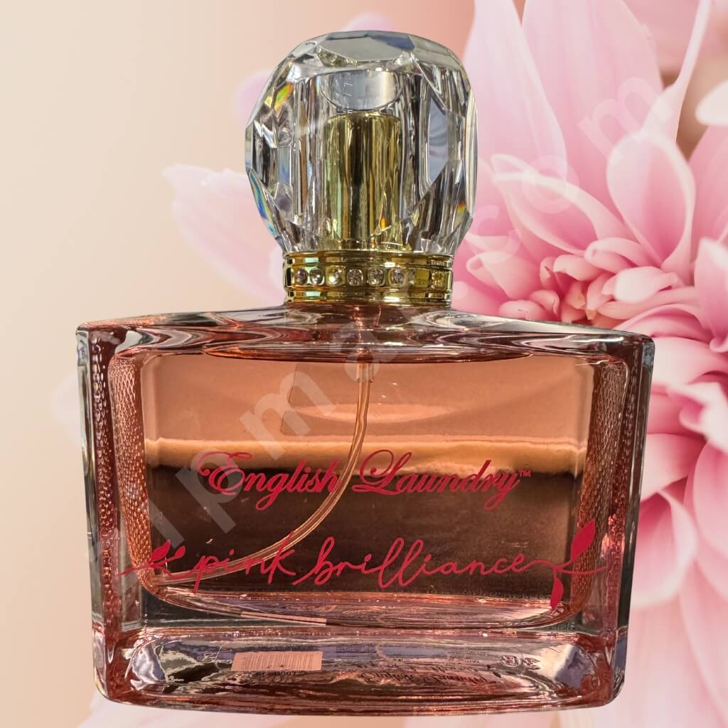 Perfume bottle labeled 'Pink Brilliance' with pink flowers in the background