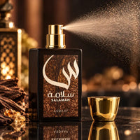 Thumbnail for Asdaaf Salamah perfume in a black bottle with brown textured label and Arabic script, spraying from a gold atomizer next to the gold cap