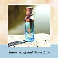 Thumbnail for Shimmering and Sweet Blue fragrance bottle displayed on a natural stone surface by the water
