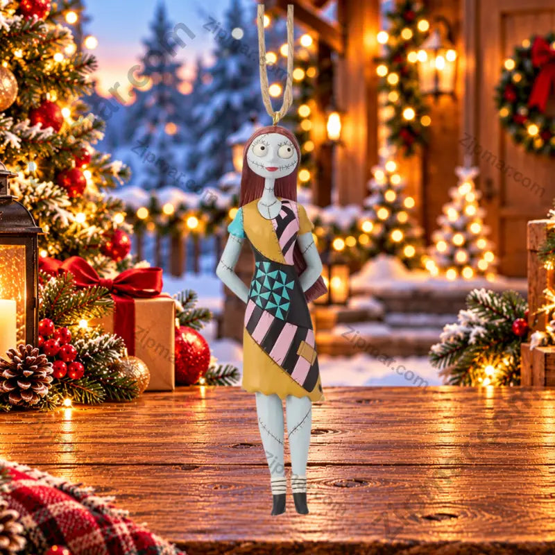 Enesco Jim Shore Sally ornament from Nightmare Before Christmas — rag doll in colorful patchwork folk art dress with teal, pink, black and gold panels, snowy Christmas cabin scene