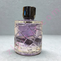 Thumbnail for Perfume bottle with geometric design on a textured surface