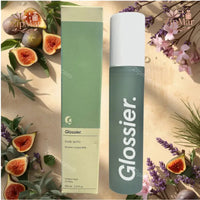 Thumbnail for Glossier Sandstone Body Spritz 3.4 fl oz bottle and box displayed with sliced figs, lavender, and greenery