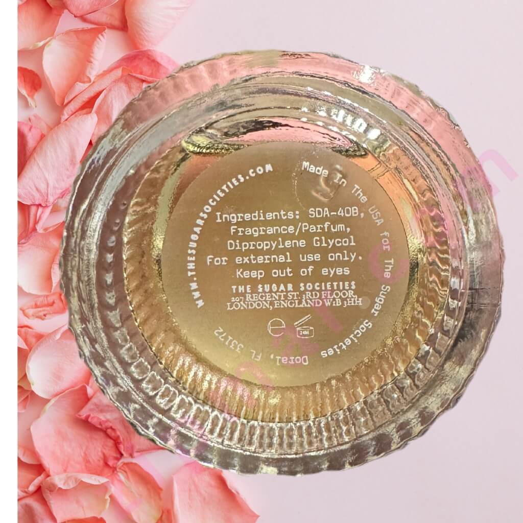 Gold container lid with text on a pink floral background