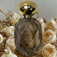 Thumbnail for Decorative perfume bottle with gold cap on a background of white roses