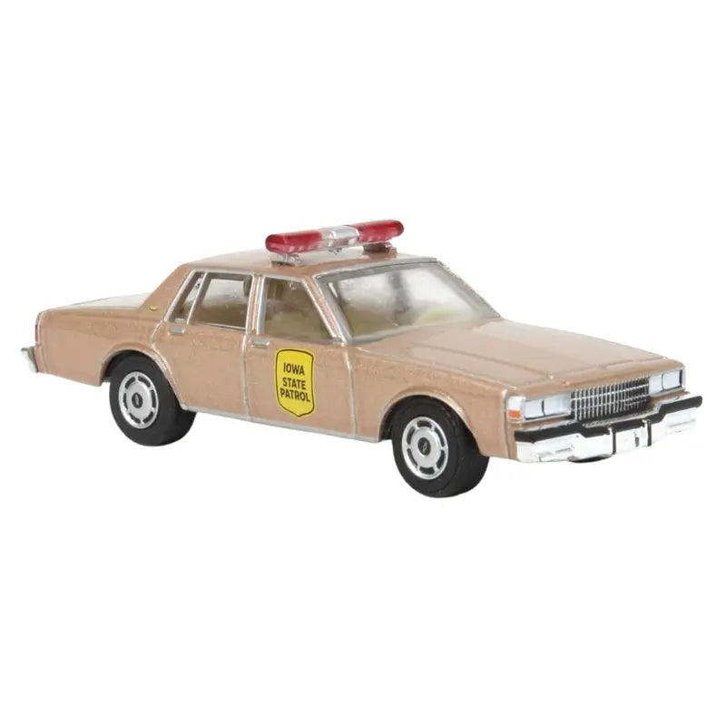Front three-quarter view of the GreenLight 1987 Chevrolet Caprice Iowa State Patrol 1:64 scale diecast car showing tan paint and light bar.