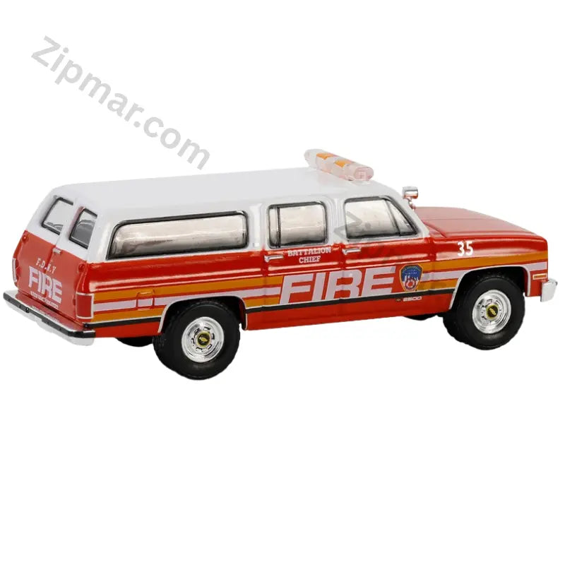 Red and white 1991 Chevrolet Suburban FDNY Battalion Chief 1:64 diecast car rear three quarter view with FIRE graphics