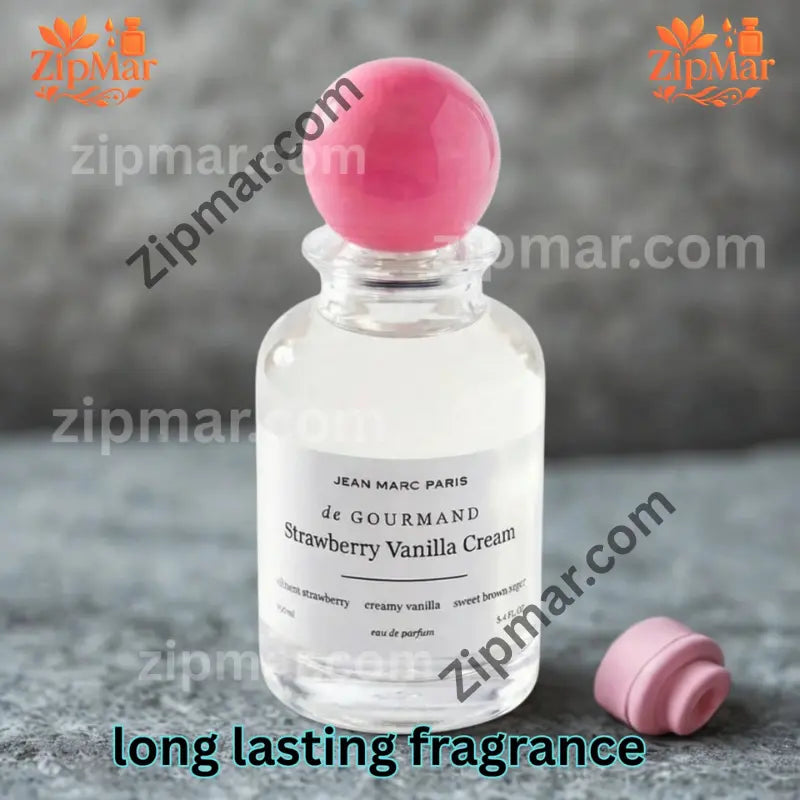 Jean Marc Paris de Gourmand Strawberry Vanilla Cream eau de parfum bottle with pink ball cap on a gray stone surface