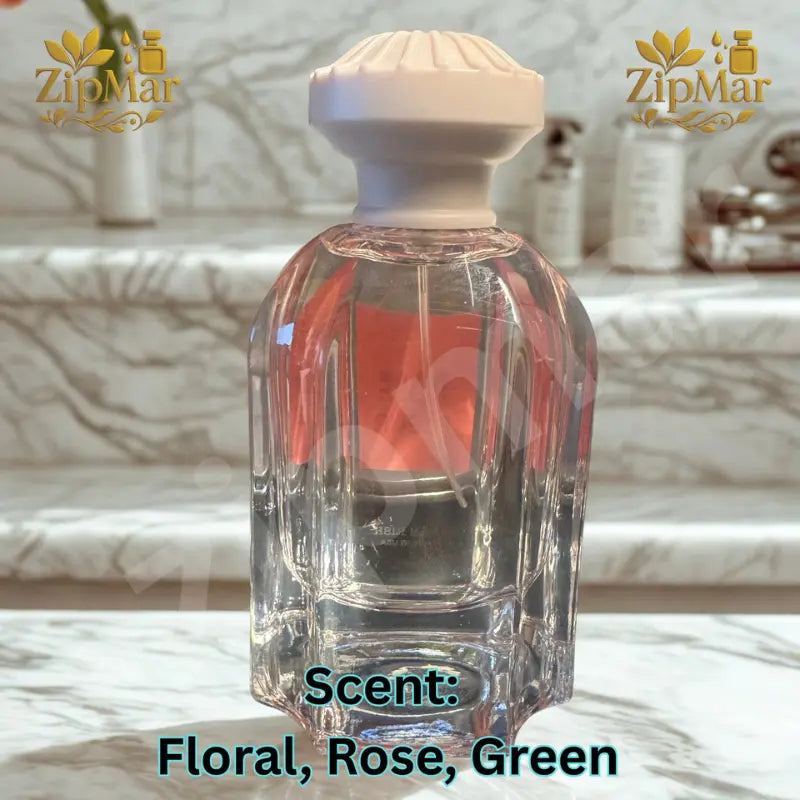 Jean Rish Rose Fleur fluted clear glass bottle with carved cream cap, back view on a marble step