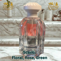 Thumbnail for Jean Rish Rose Fleur fluted clear glass bottle with carved cream cap, back view on a marble step