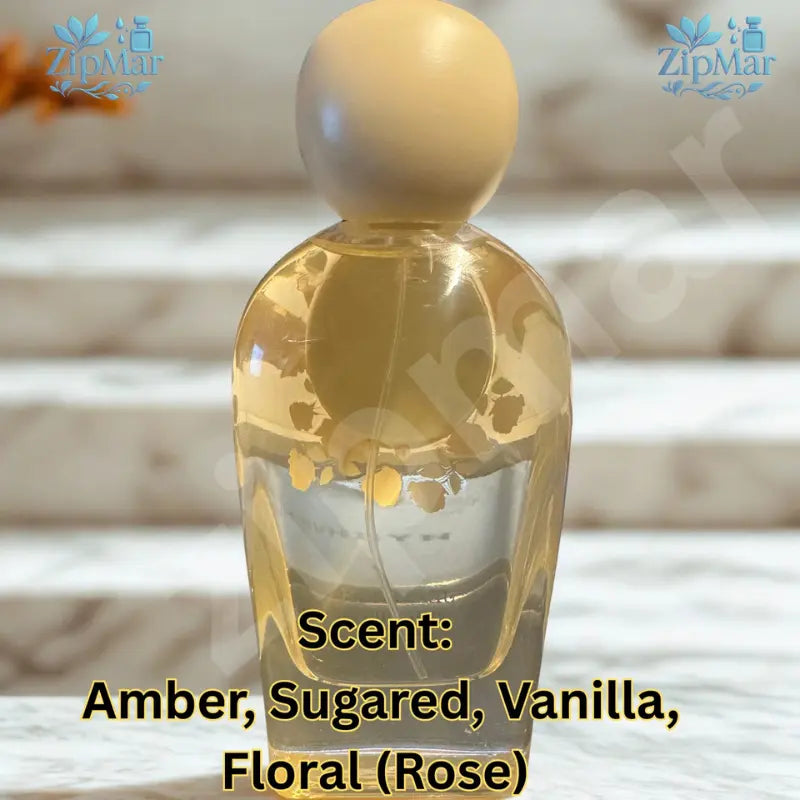 Jean Rish Sugared Amber Eau de Parfum clear glass bottle with cream cap on a marble step