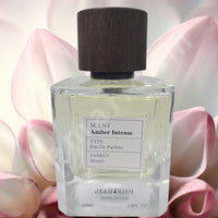 Thumbnail for Perfume bottle labeled 'Amber Intense' by Jean Rash with a wooden cap on a soft pink floral background.