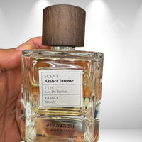 Thumbnail for Perfume bottle labeled 'Scent Amber Intense' held by a hand on a white background