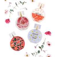 Thumbnail for Kensie Fragrance Collection four mini perfume bottles lifestyle shot with flowers and greenery