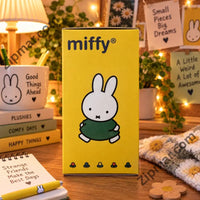 Thumbnail for Yellow Miffy Color Pop plush keychain box on a desk with cozy props