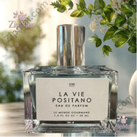 Thumbnail for La Vie Positano Eau de Parfum 1.0 oz by Le Monde Gourmand angular faceted clear glass bottle with chrome pump, No. 030, against soft green botanical background