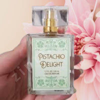 Thumbnail for Perfume bottle labeled 'Pistachio Delight' held in front of a pink flower.