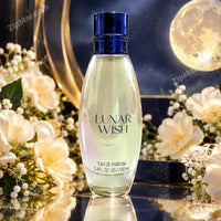 Thumbnail for Lunar Wish Eau de Parfum 3.4 fl oz 100 mL oval glass bottle with navy cap beside white flowers and a full moon