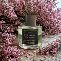 Thumbnail for Imperial Woods cologne bottle with pink flowers on a wooden surface