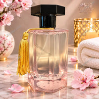 Thumbnail for MG Studio Japanese Cherry Blossom Room Spray pink glass bottle back with black cap and gold tassel beside cherry blossoms
