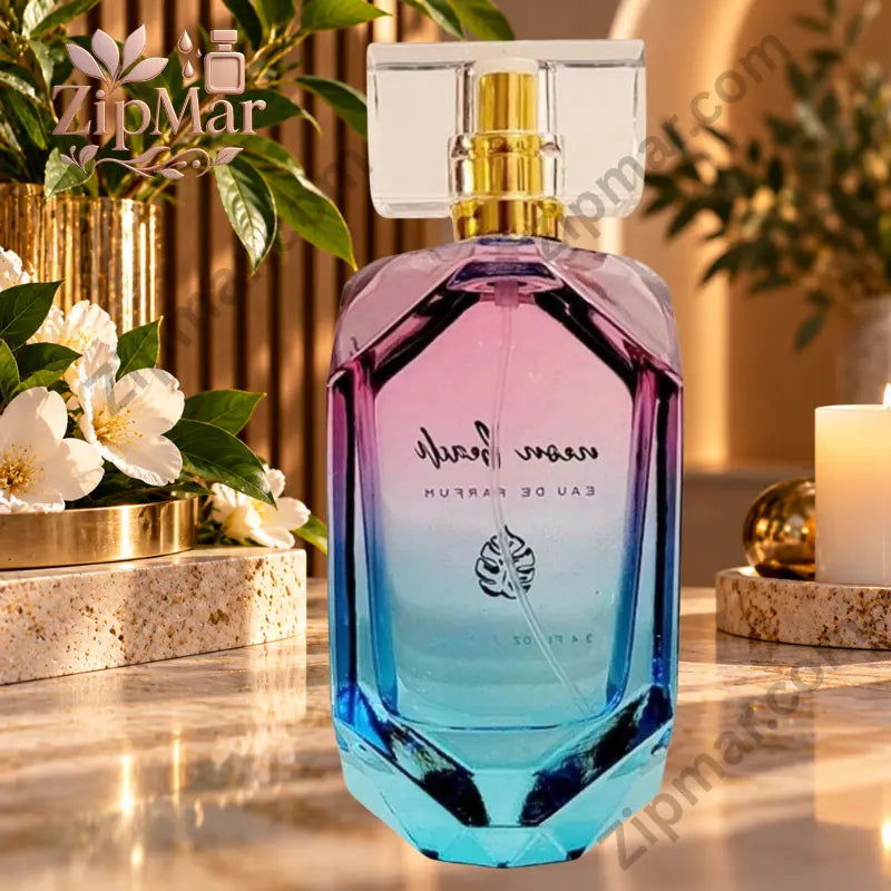 Neon Beach Eau de Parfum pink purple teal gradient faceted glass bottle back view on marble surface with white jasmine gardenia blossoms tropical green leaves gold cylindrical vase and white pillar candle neon beach front label visible in reverse through bottle glass in warm golden indoor light