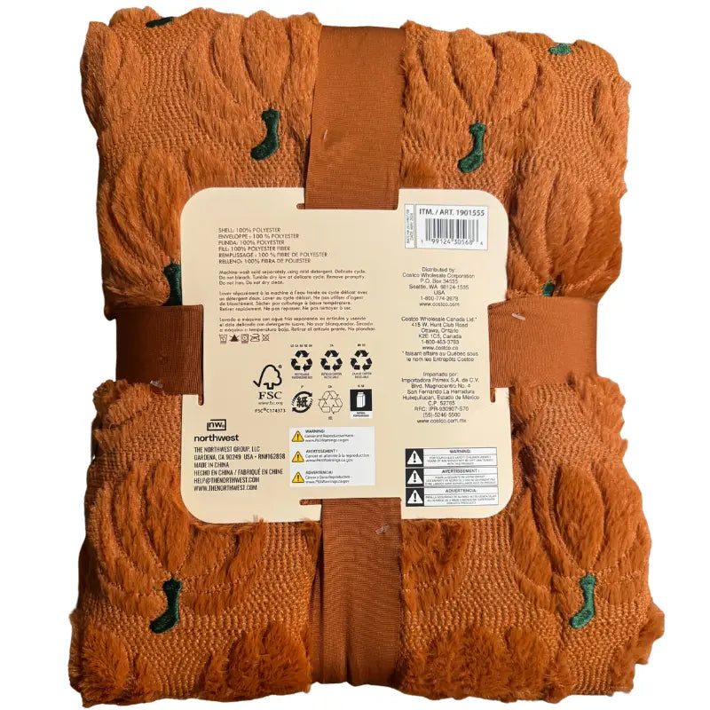Back label view of The Northwest Group pumpkin throw blanket showing Costco item number 1901555, care instructions, and material specifications