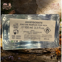 Thumbnail for Straight-on view of Aristocrate EDP bottle on natural stone slab with white flowers and amber accents