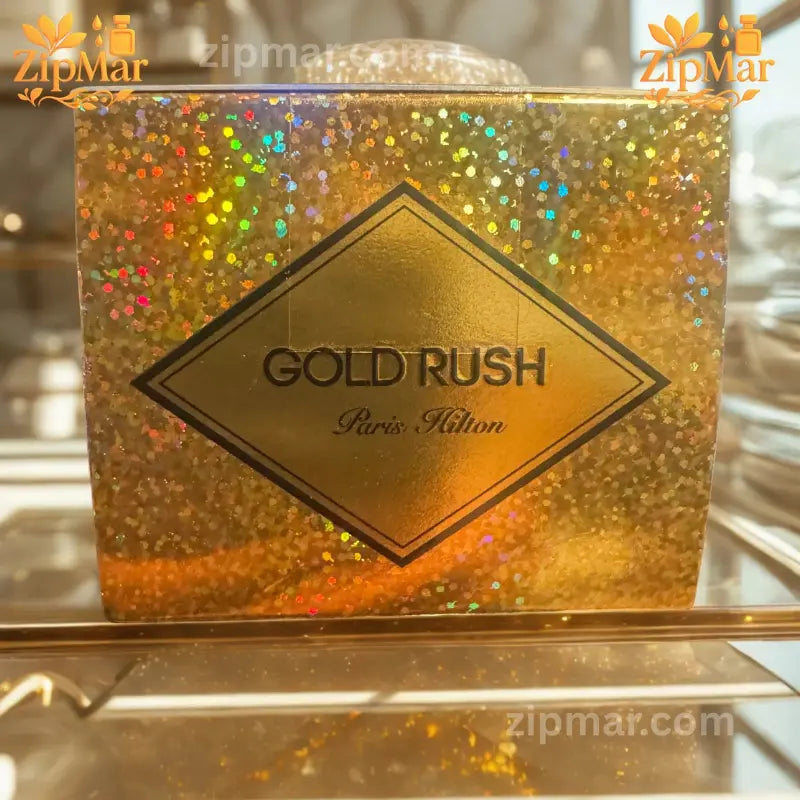 Top view of Paris Hilton Gold Rush EDP box showing diamond logo label on gold glitter finish