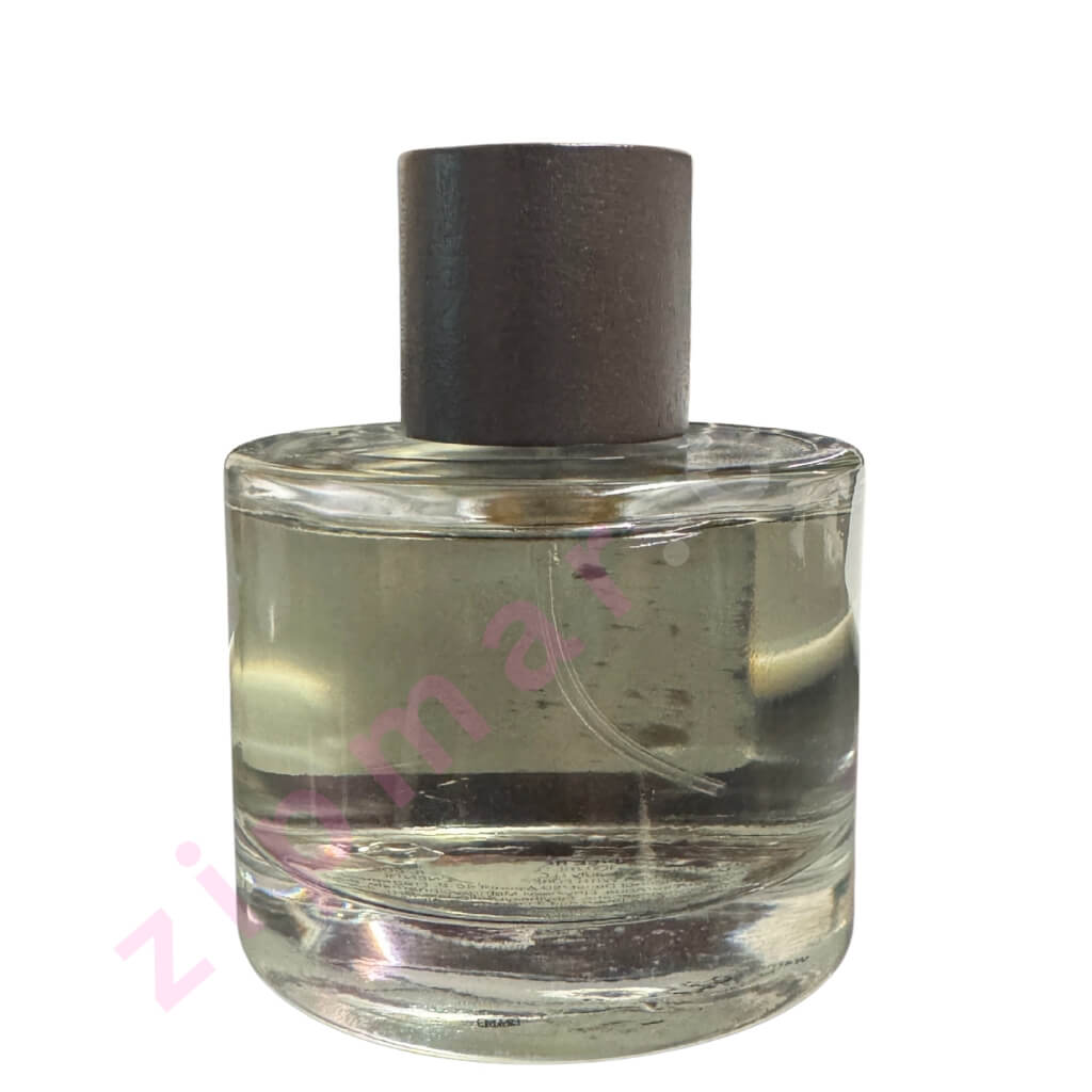 Clear glass perfume bottle with a dark brown cap on a white background backside