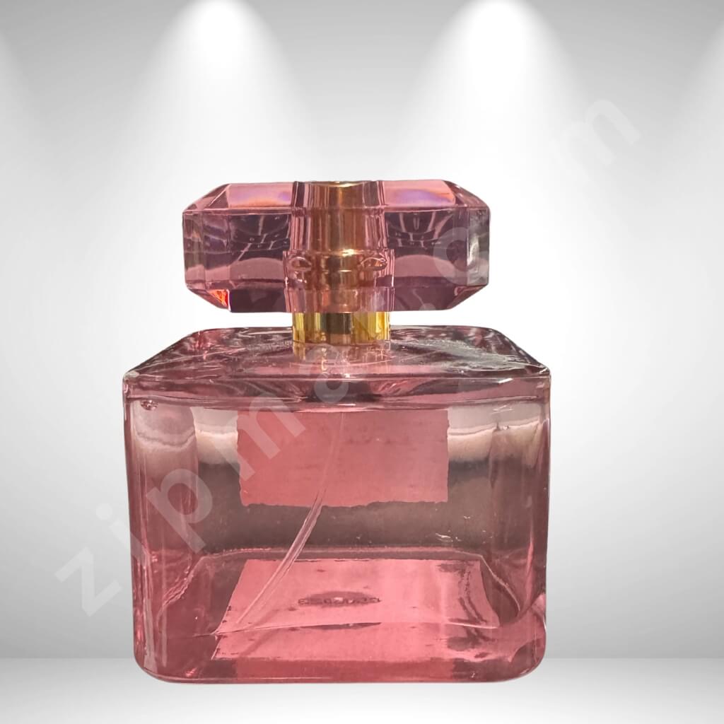 Pink perfume bottle with a gold cap on a white background