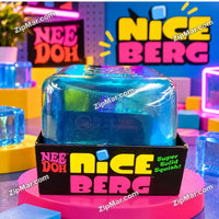 Thumbnail for Schylling NeeDoh Nice Berg translucent blue iceberg squish toy displayed in box on a pink display pedestal