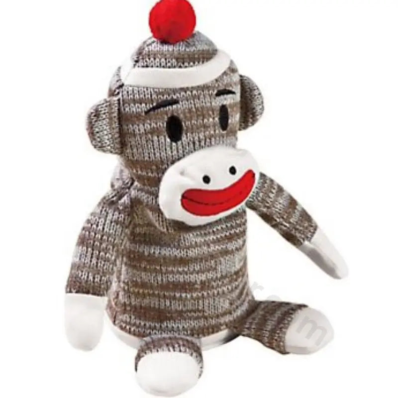 Sock monkey plush toy in brown and gray knit with a red pom pom hat, white face and red smile, sitting upright