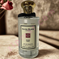 Thumbnail for Perfume bottle labeled 'Olivia Blake London' with a gold cap on a textured surface.