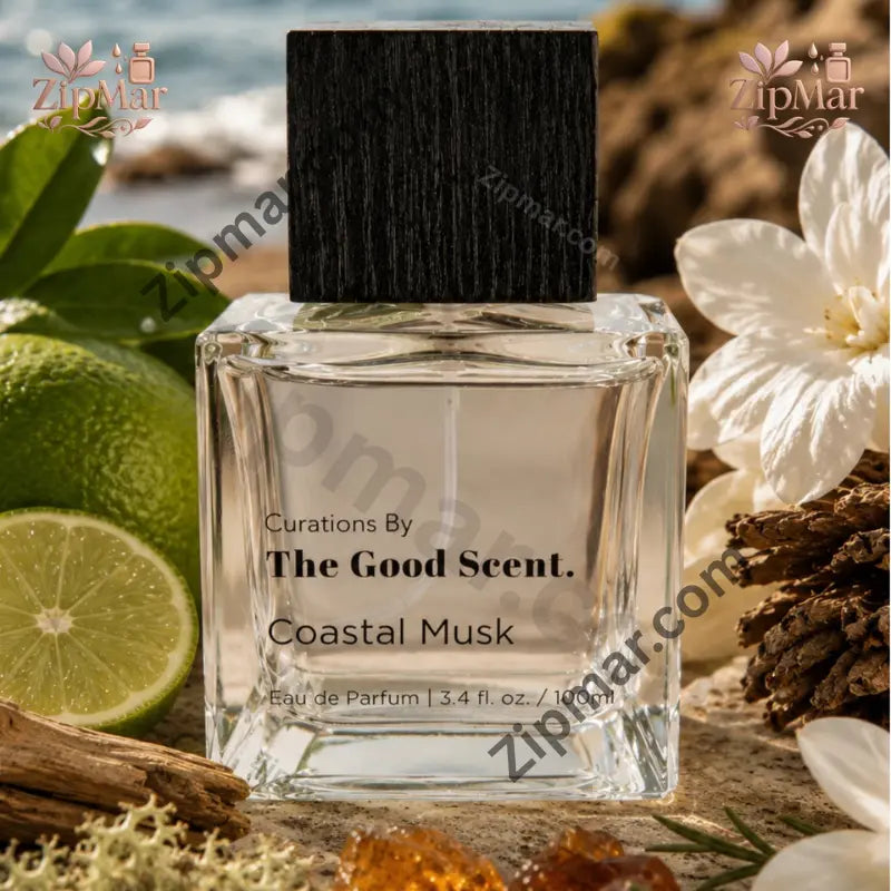 Curations By The Good Scent Coastal Musk eau de parfum 3.4 fl oz clear square glass bottle with black wood grain cap on a beach with limes and white flowers