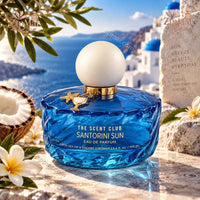 Thumbnail for The Scent Club Santorini Sun Eau de Parfum 3.4 fl oz deep blue bottle with frosted ball cap and gold starfish charm in Santorini-themed setting