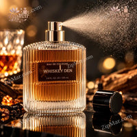 Thumbnail for Whiskey Den Eau de Cologne 100 mL by Tru Fragrance & Beauty ribbed glass bottle with gold pump spraying mist, styled with whiskey glass and amber crystals in dark lounge setting