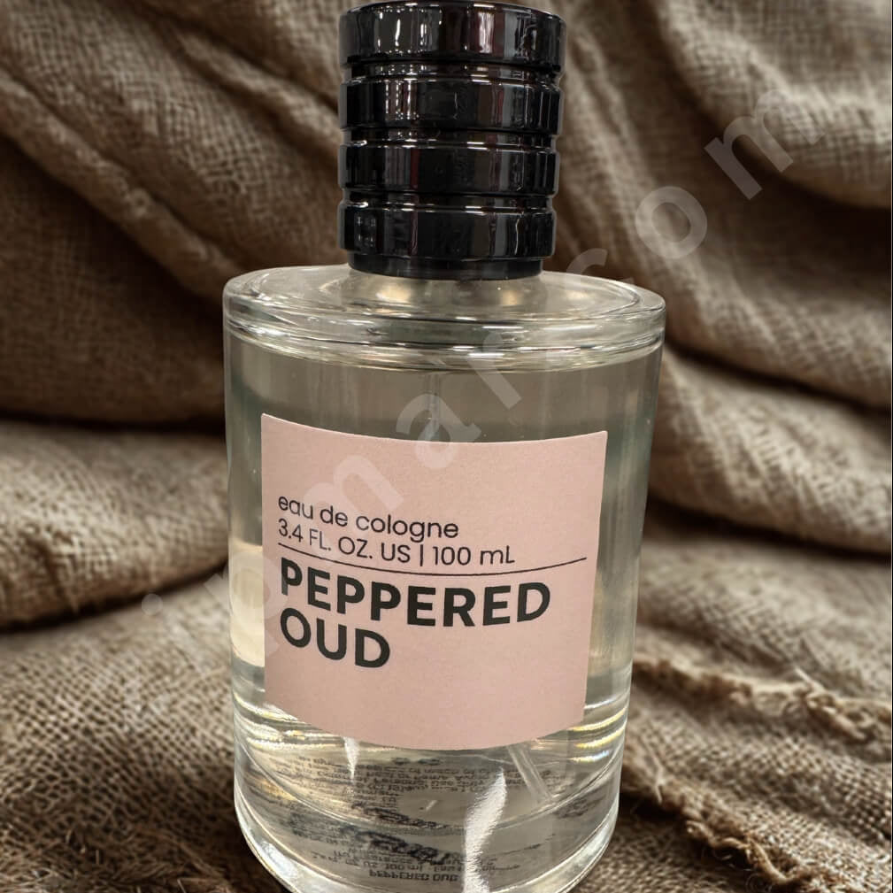 Perfume bottle labeled 'Peppered Oud' on a textured fabric background